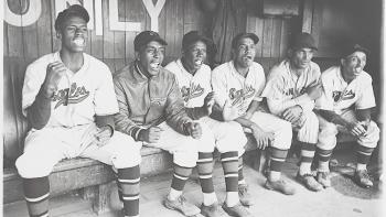 The League Movie: A picture of a Black baseball team cheering in a dugout