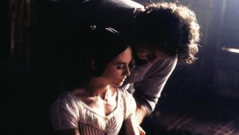The Piano Movie: A couple embraces in a dimly lit room, sunlight casting a soft glow.