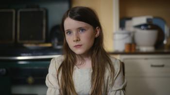 The Quiet Girl: A young girl sits in a kitchen