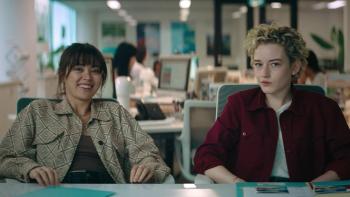The Royal Hotel: Liv and Hanna smile and look toward camera while speaking in an office to a job recruiter.