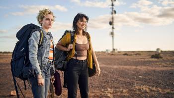 The Royal Hotel: Hanna and Liv, both with large backpacks on their shoulders are in the remote Australian Outback.