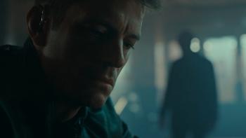 The Silent Hour: Joel Kinnaman sits in dimly-lit bar with a figure standing in the background
