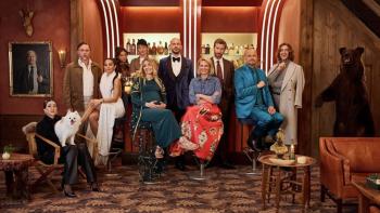 The Storm movie: the cast in stylish attire posing together in a warmly lit room