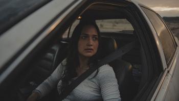 The Unknown Country movie: Lily Gladstone looks outside of the driver’s side window of her Cadillac