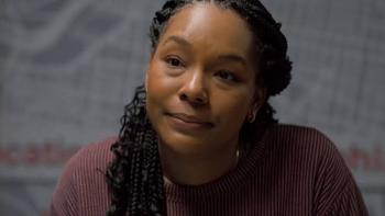 The Body in the Locker: Black Woman with braids sitting, wearing a maroon sweater, neutral expression.