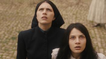 The First Omen Movie: Margaret and Carlita stand looking upward, shocked at something they see