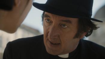 The First Omen Movie: Father Brennan speaks with Margaret, who's just off-camera; he seems to be warning her of something