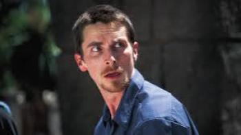 The Machinist Movie: Man in blue shirt looking to the side with a concerned expression.