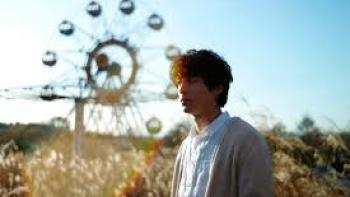 The Parades: A man stand by a Ferris wheel 