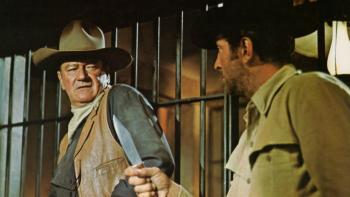 The Sons of Katie Elder: Two White men in a jail cell, one holds up a dagger.