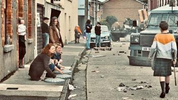 The Troubles - A Dublin Story: A child walks down a messy street amid a protest