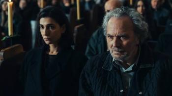 The Truthers Movie: Two people sit solemnly in a dimly lit church with candles behind them.