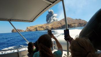 Passengers on boat photograph Whakaari/White Island volcano eruption.