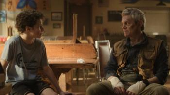 Tiny Fugitives movie: Camp counselor Bob (Johnny Knoxville) and Jacob (Benjamin Pajak) sit and talk in a dimly lit room