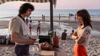 Tony movie: Dominic Sessa is a young Anthony Bourdain serving a clambake on the beach; Emilia Jones talks to him with her arms crossed
