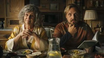 Too Old for Fairy Tales 2: An older, grey haired woman sits next to a man with a sleepy, worried look on his face at a table