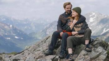 Too Old for Fairy Tales 2: A lady and a man sit together on the top of a mountain in an embrace