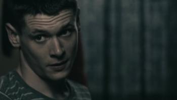 Tower Block: Jack O'Connell stands in front of drawn curtains.