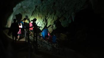 The Trapped 13 - How We Survived the Thai Cave: Thai boys illuminated by torchlight in an otherwise pitch black cave.