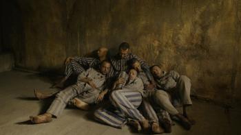 Triumph of the Heart movie: Marcin Kwaśny lies on the ground with other prisoners