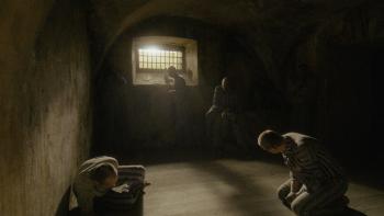 Triumph of the Heart movie: Marcin Kwaśny kneels to pray inside his prison cell