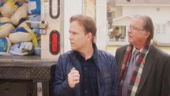 The Great Turkey Town Miracle Movie: Two White men stand next to each other looking at a truck full of frozen turkeys