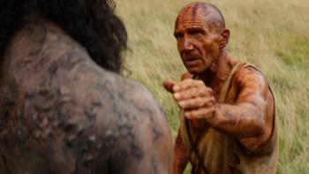 28 Years Later: The Bone Temple Movie: Dr. Ian (Ralph Fiennes) reaches to touch the shoulder of a large alpha zombie