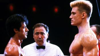 Rocky IV movie: Rocky faces off against his much taller, blond opponent in the ring, the ref between them