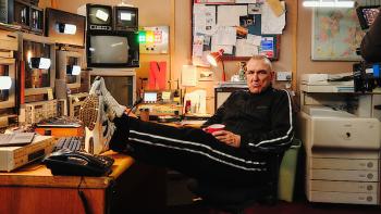 Untold UK -- Vinnie Jones: Vinnie Jones in tracksuit sits relaxed in cluttered control room, feet on desk