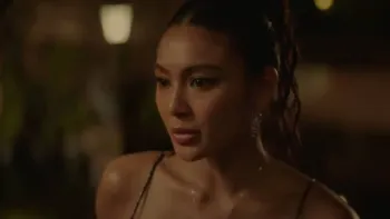 Uninvited movie: Filipino woman with hair up in black dress looks seriously ahead while at a fancy party