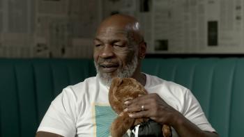 Unstuffed: A Build-a-Bear Story: Boxer Mike Tyson is seated holding a small teddy bear.