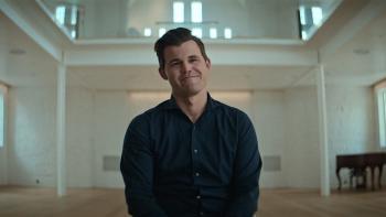 Untold: Chess Mates movie: Magnus Carlsen sits and smiles in a large white room