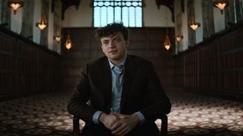 Untold: Chess Mates movie: Hans Niemann sits in a large, dark room