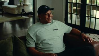 Untold: Jail Blazers movie: Bonzi Wells smiles as he sits on a couch