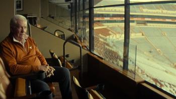 Untold: The Testimony of Vince Young movie: Mack Brown sits in a seat in a press box at the University of Texas