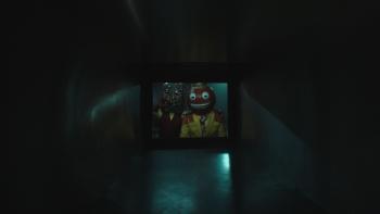 V/H/S/Halloween Movie: A bug-eyed, red-faced, smiling creature peers down an air-duct
