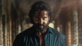 Vikram Vedha: A bearded Indian man stares intensely straight down the camera
