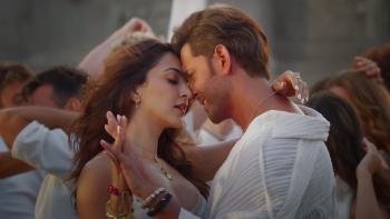 War 2: Couple in an intimate dance pose surrounded by other dancers