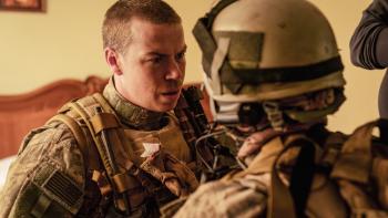 Warfare Movie: In full Navy SEAL gear, Erik (Will Poulter) speaks seriously to someone whose back is to viewers