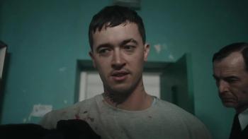 Wasteman: Tom Blyth stands with blood on his prison clothes while a guard stands behind him