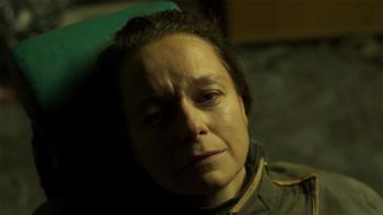 2073: Samantha Morton lying down staring up to the sky with a look of concern on her face
