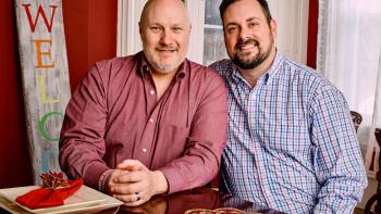 till from We Live Here: The Midwest: Seated and facing the camera are Russell Exlos-Raber (left) and Mark Exlos-Raber who are a White LGBTA+ married couple from Ohio, wearing causal attire