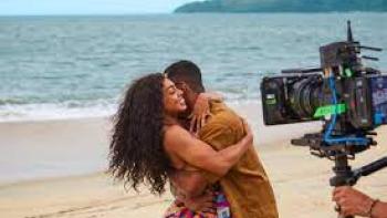Wedding Games scene 3: Black man and woman embrace on the beach as the camera rolls
