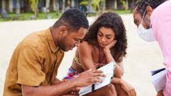 Wedding Games scene 2: Black man and woman look at something on the beach
