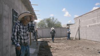 Julían Moreno oversees laborers build his new family home.