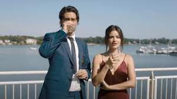 Which Brings Me to You Movie: Nat Wolff and Lucy Hale hold their drinks at a beach club wedding reception