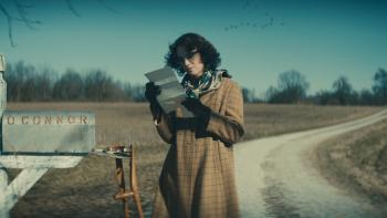 Wildcat Movie: Flannery O'Connor (Maya Hawke) stands by a mailbox near a country road, reading a letter