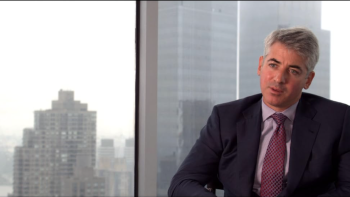 Inside Job: A White man sits in front of a high-up view of skyscrapers as he's interviewed