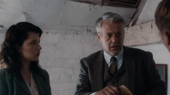 Wolves of War: Anastasia Martin and Rupert Graves stand holding papers