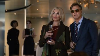 The Woman in Cabin 10: Hannah Waddingham and David Morrissey each hold a glass of champagne at a soiree on a boat